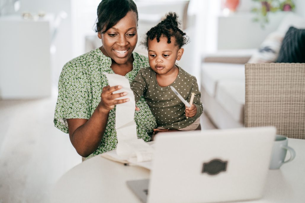 Woman going over finances with child in lap.