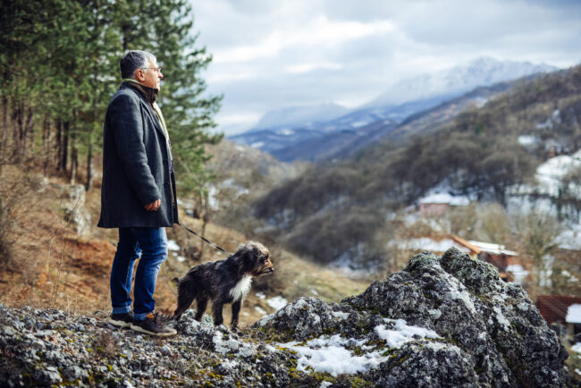 Man walking dog in nature.