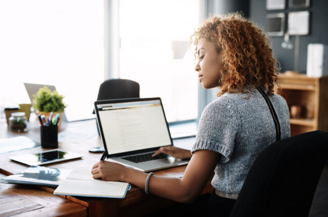 Shot of a young businesswoman working on a laptop in an office