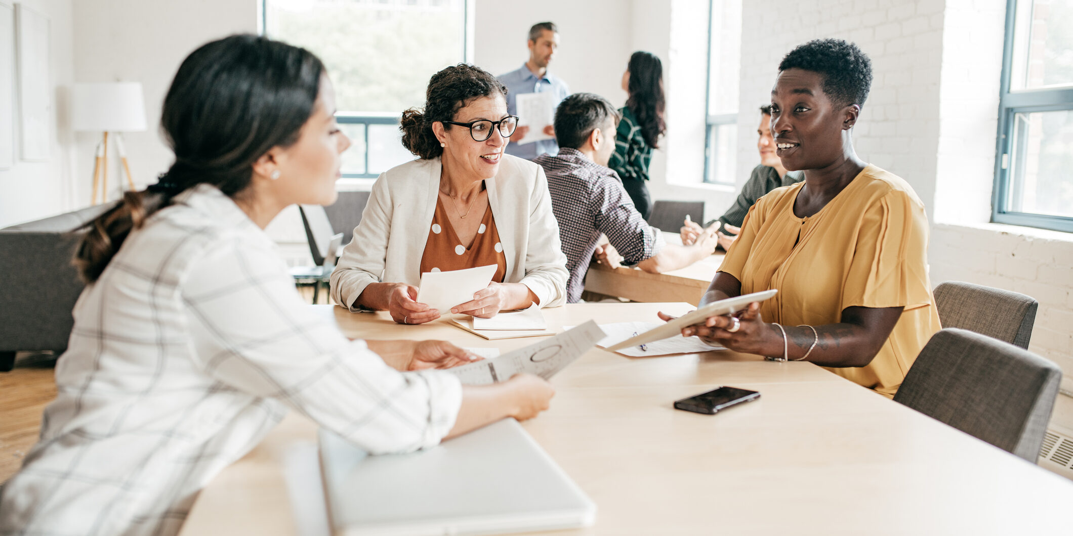 Women around a table discussing work.