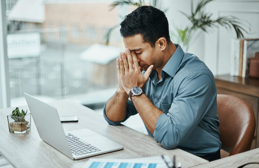 Young man anxious at work.