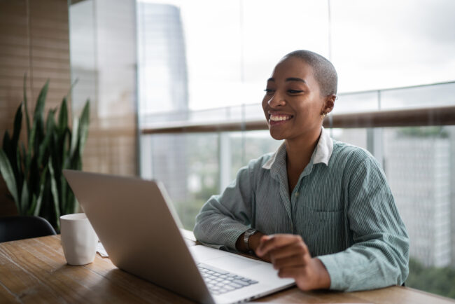 Young woman working and doing a virtual business meeting on laptop at home