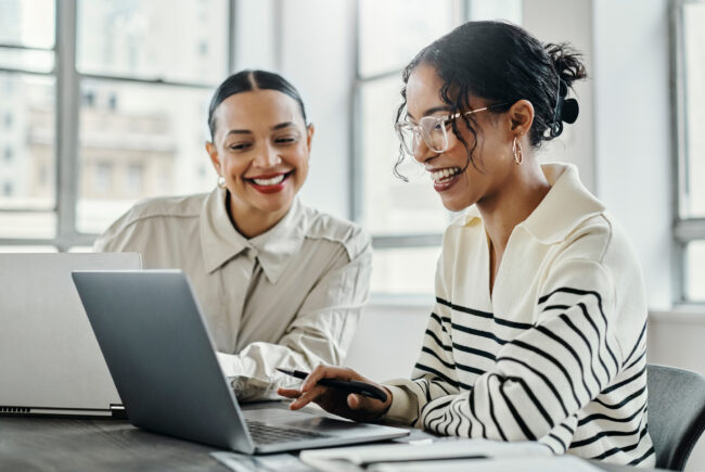 Business women, laptop and teamwork in startup office for data analysis team reading, laughing and talking while online. Female management employees working together kpi report, research and planning