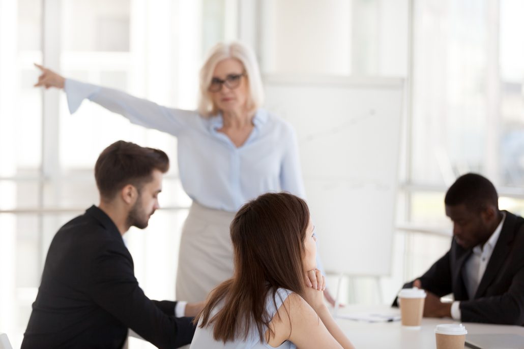 Disgruntled young employee intern ignoring mature angry executive firing incompetent worker asking to leave group office meeting, different age generations conflict, discrimination at work concept