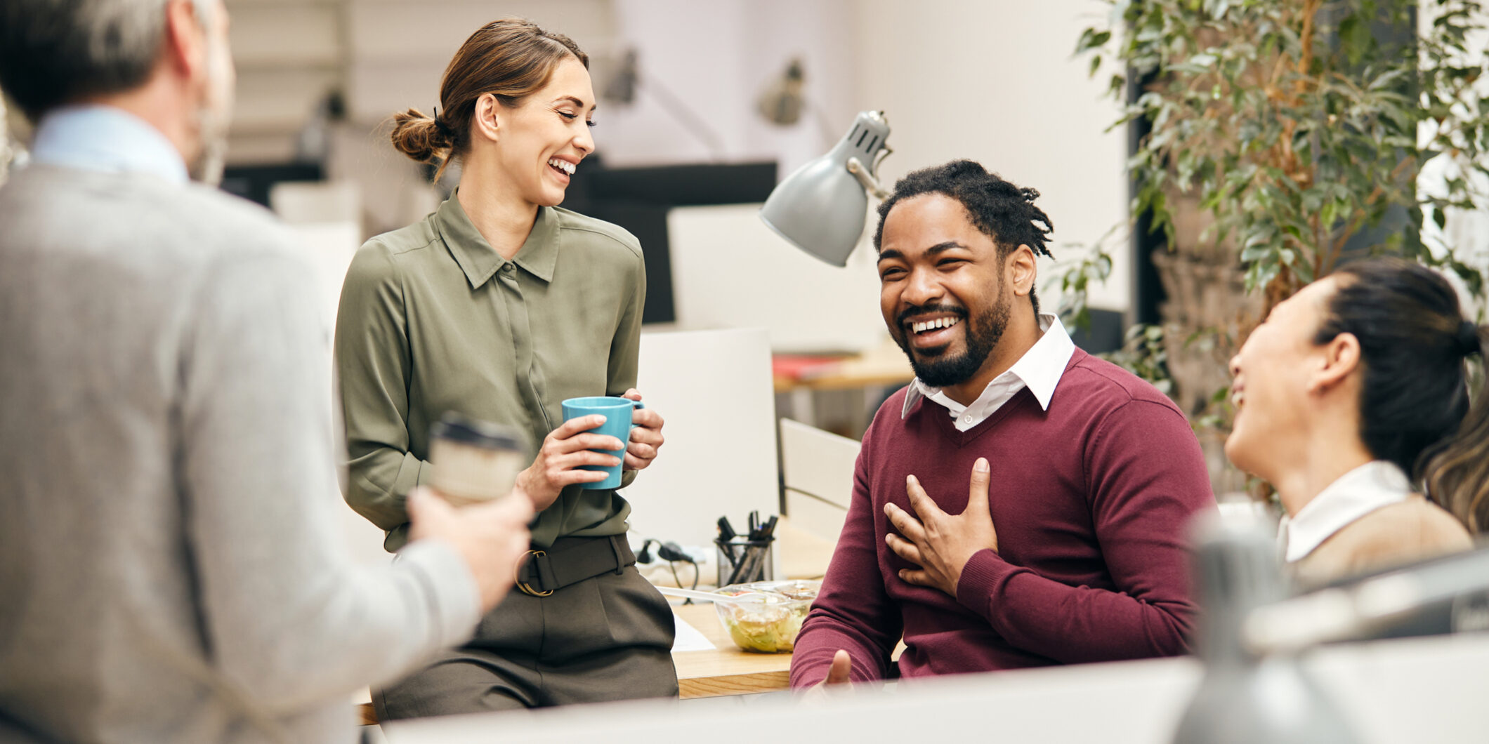 Happy business team having fun while talking on their coffee break in the office.