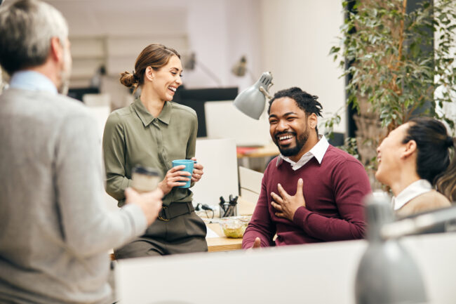 Happy business team having fun while talking on their coffee break in the office.
