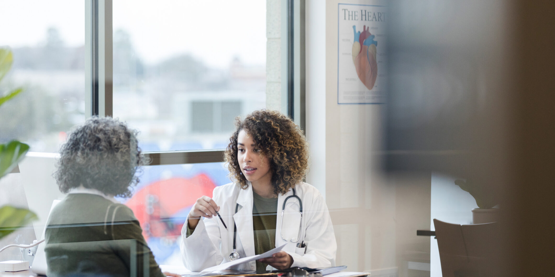 Female doctor and unrecognizable mature patient discuss treatment