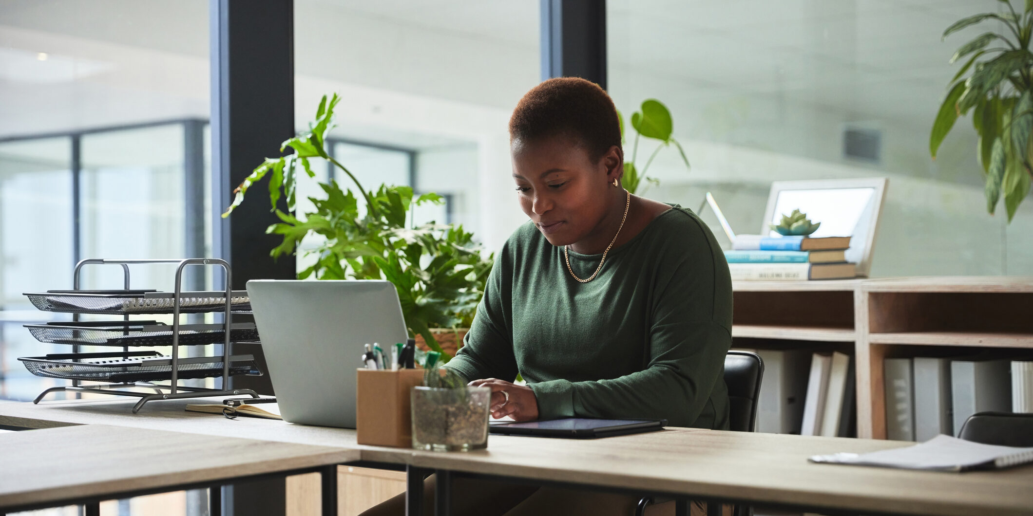 Woman, typing and laptop in a office with digital work at a desk with email at job. African female person, technology and ux designer on a website doing internet research at a company working