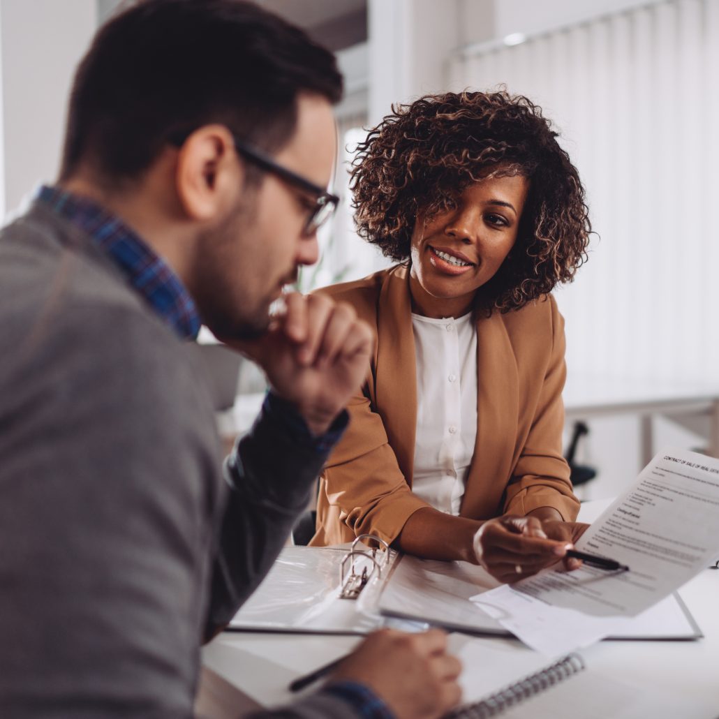 Woman helping a man understand documents.
