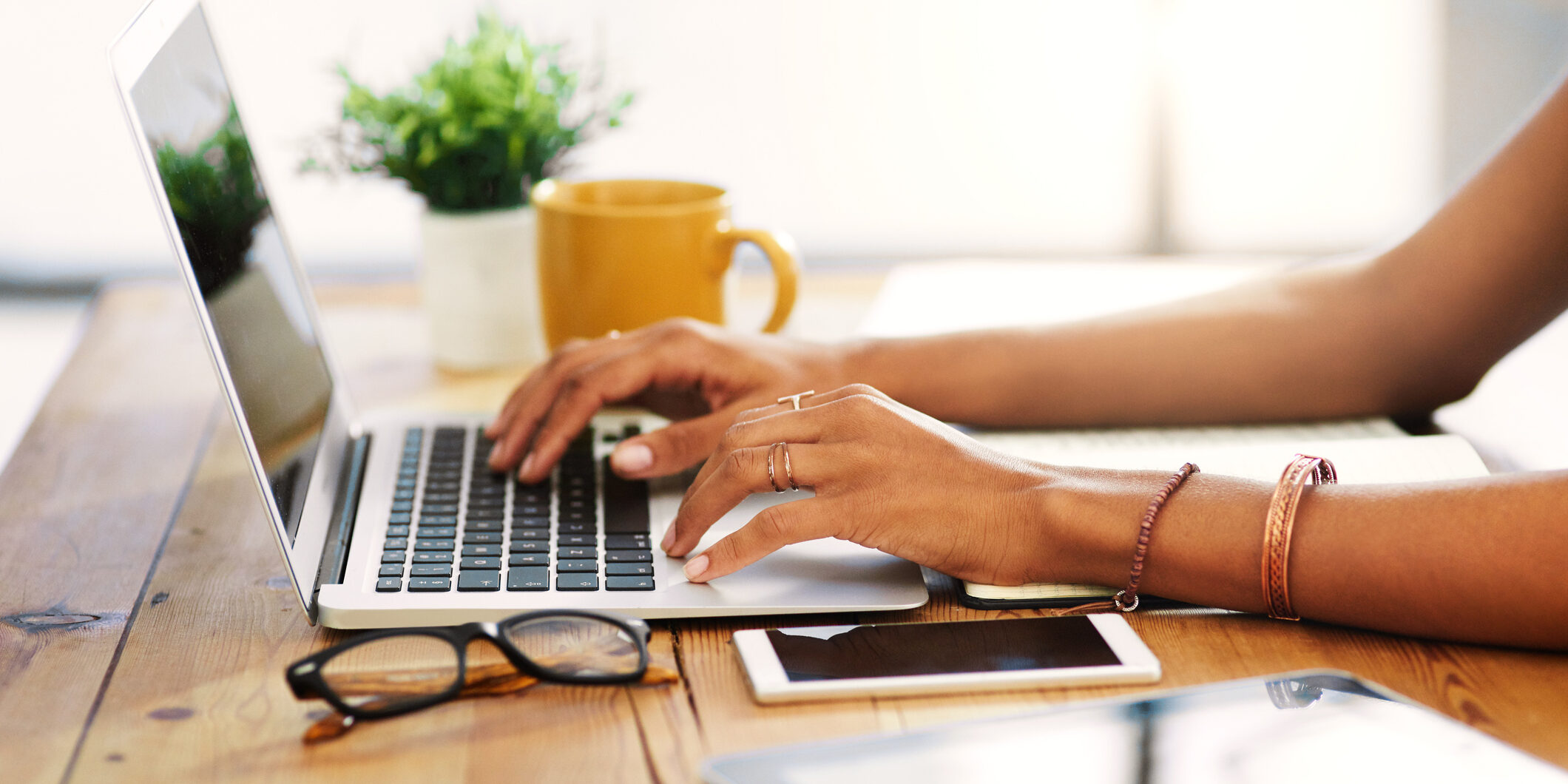Cropped shot of an unrecognizable businesswoman sitting alone and typing on her laptop during the day at home